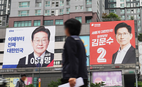 제21대 대통령선거 대형 현수막을 보며 지나치는 시민. 연합뉴스. 