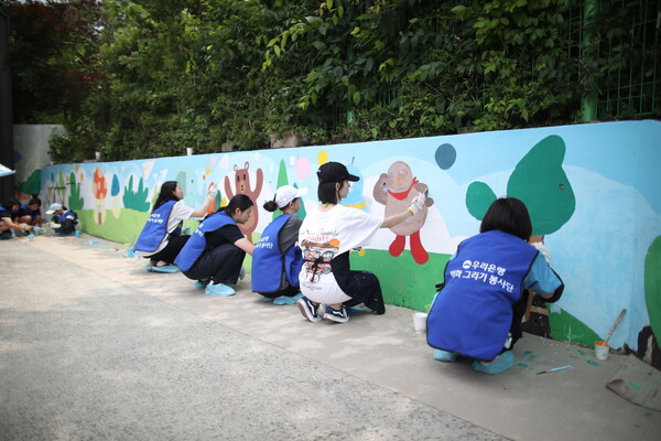 벽화그리기 봉사에 참여중인 우리은행 임직원 및 가족 봉사단원들. 우리은행 제공.