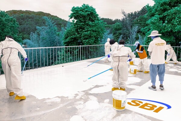 쿨루프 도료를 시공중인 봉사단원들. SBI저축은행 제공.