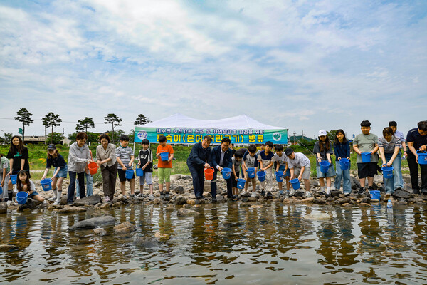 산청군이 경호강 일원에서 지역 학생 및 주민들과 함께 은어 치어 방류 행사를 진행하고 있다. ⓒ산청군
