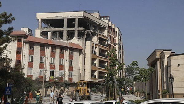 13일 이스라엘군 공습으로 파괴된 이란 테헤란 시내 건물 앞에 사람들이 모여 있다. 연합뉴스 제공.