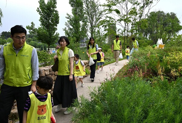 엄마, 아빠 손을 잡고 플로깅 활동 중인 어린이들. NH농협손보 제공.