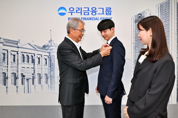 새 가족이 된 동양생명·ABL생명 직원에게 그룹 보조휘장을 달아주는 임종룡 회장. 우리금융 제공.