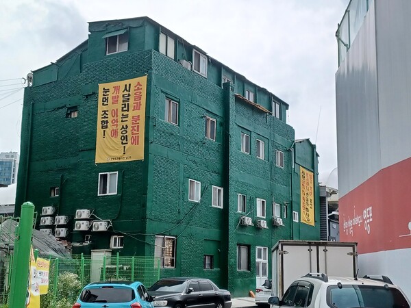 대우건설과 두산건설 컨소시엄이 서울시 영등포구 영등포동5가 32-8번지 일원에 공급하는 '리버센트 푸르지오 위브'와 연접한 영등포 전통시장 상인회 입주 건물 벽면에 공사 소음과 분진을 성토하는 현수막이 걸려 있다. 김태현 기자