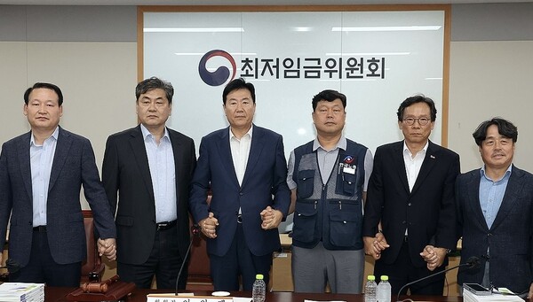 최저임금위원회 사용자위원 운영위원인 류기정 한국경영자총협회 전무(왼쪽 두 번째)와 근로자위원 운영위원인 류기섭 한국노총 사무총장(오른쪽 두 번째)이 10일 정부세종청사에서 열린 제12차 전원회의에서 내년 최저임금을 시간당 1만320원으로 합의했다.