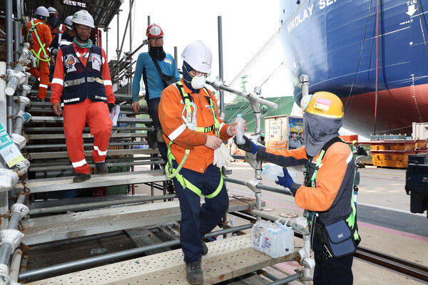 10일 한화오션 안전관리자가 작업자들에게 얼음 생수를 전달하고 있다. 한화오션 제공. 