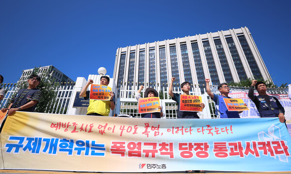 민주노총 조합원들이 11일 서울 종로구 정부서울청사 앞에서 정부 규제개혁위원회(규개위)의 폭염 규칙 통과 촉구 기자회견을 하고 있다. 연합뉴스. 