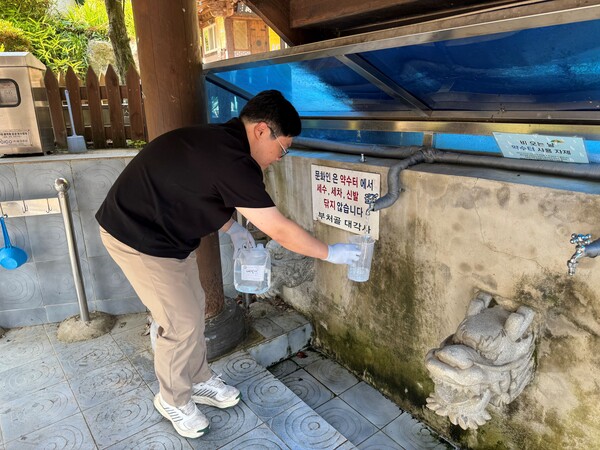광주시 보건환경연구원이 남구 대각사 약수터에서 수질검사를 위해 샘플을 채쥐하고 있다./광주시