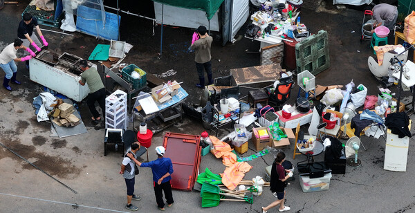 18일 침수 피해를 본 대구 북구 노곡동 한 가정집에서 주민과 공무원들이 복구 작업을 하고 있다. 연합뉴스. 