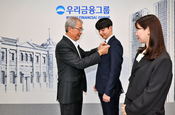 지난 7월 1일 새 식구가 된 동양생명과 ABL생명 직원에게 우리금융 뱃지를 달아주는 임종룡 회장. 우리금융 제공.