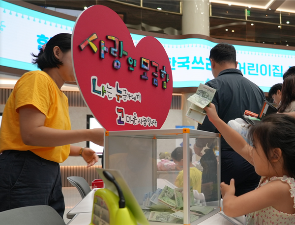 플리마켓 판매 수익을 모금함에 넣고 있는 어린이. 한국투자증권 제공.