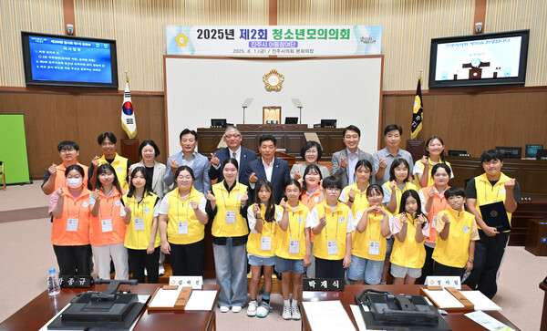 진주시 아동참여단 학생들이 진주시의회 본회의장에서 열린 ‘2025년 제2회 청소년 모의의회’를 마치고 참석 시의원들과 함께 기념촬영을 하고 있다. ⓒ진주시의회