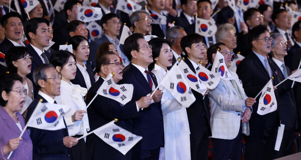 이재명 대통령과 김혜경 여사가 15일 서울 세종문화회관에서 열린 80주년 광복절 경축식에서 참석자들과 함께 태극기를 흔들며 광복절 노래를 제창하고 있다. 연합뉴스. 