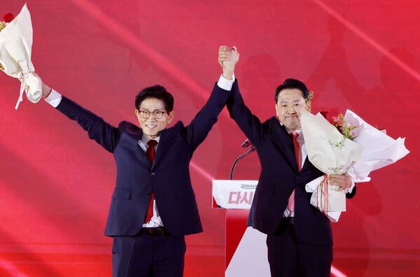 22일 충북 청주시 흥덕구 청주오스코에서 열린 국민의힘 제6차 전당대회에서 결선에 진출한 김문수, 장동혁 당 대표 후보가 꽃다발을 건내 받은 뒤 손을 들어올리고 있다. 연합뉴스. 