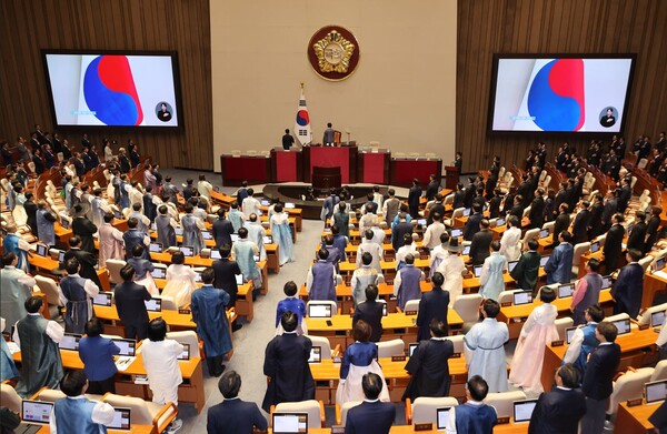 1일 서울 여의도 국회 본회의장에서 열린 제429회 정기국회 개회식에서 의원들이 국기에 경례하고 있다. 이날 개회식에는 여야 대부분 의원들은 한복 차림을, 국민의힘 의원들은 근조 리본을 단 상복 차림으로 참석했다. 연합뉴스. 