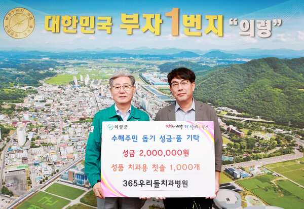 오태완 의령군수(왼쪽)와 정영주 365우리들치과병원 이사가 수해주민 돕기 성금과 물품을 기탁하고 기념촬영을 하고 있다. 의령군 제공