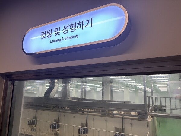 하림 라면키친 ‘컷팅 및 성형하기’ 공정 구역. 반죽된 면이 여러 롤러를 지나 얇아진 뒤 무게추를 이용해 속도를 달리하며 잘려 나가면서 특유의 꼬불꼬불한 형태를 갖추는 과정을 유리창 너머로 볼 수 있다. 박수진 기자