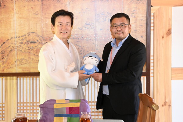 조규일 진주시장(왼쪽)이 위라데짓 푸피싯 태국 람푼 주 민선지사에게 진주 대표 캐릭터 하모를 전달하고 기념촬영을 하고 있다. 진주시 제공