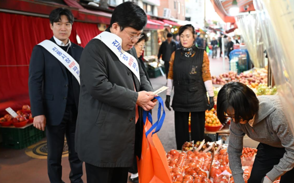 영등포 우리시장 과일상점에서 물건을 구매하는 윤창현 코스콤 사장. 코스콤 제공.