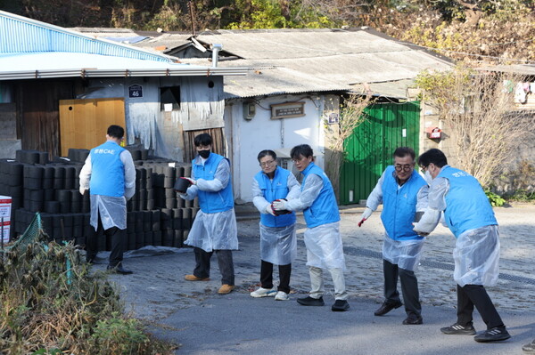 이현준 사장(왼쪽에서 세번째)을 비롯해 쌍용C&E 임직원들이 서울시 성북구 정릉3동 1통 일대서 열린 ‘사랑의 연탄 나눔’ 행사에서 연탄을 전달하고 있다. 쌍용C&E 제공