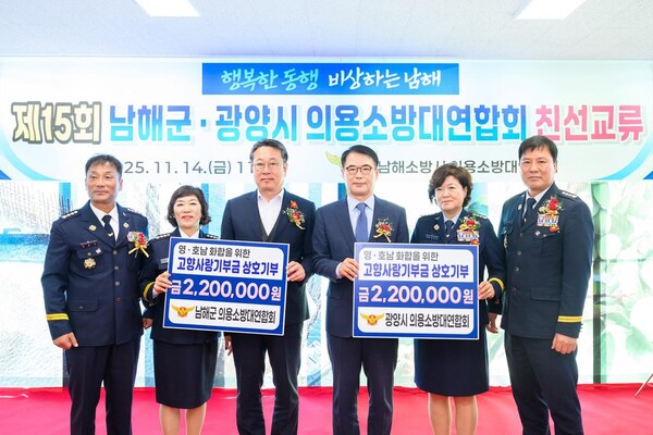 남해군·광양시 의용소방대연합회가 친선교류 행사에서 고향사랑기부금을 상호 전달하며 기념촬영을 하고 있다. 남해군 제공