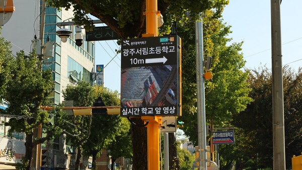 광주광역시 북구 서림초등학교 인근에 설치된 ‘스마트 아이(Smart Eye)’ 교통안전 솔루션이 실시간 영상과 안내 문구로 보행자와 운전자에게 위험을 알리고 있다. 현대백화점그룹 제공