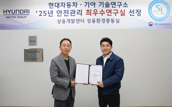 상용환경풍동실 앞에서 현대자동차∙기아의 박상현 상용LCM담당 부사장(완쪽)과 이강웅 상용연비운전성시험팀 책임연구원이 기념 사진을 촬영하고 있다. 현대자동차·기아 제공